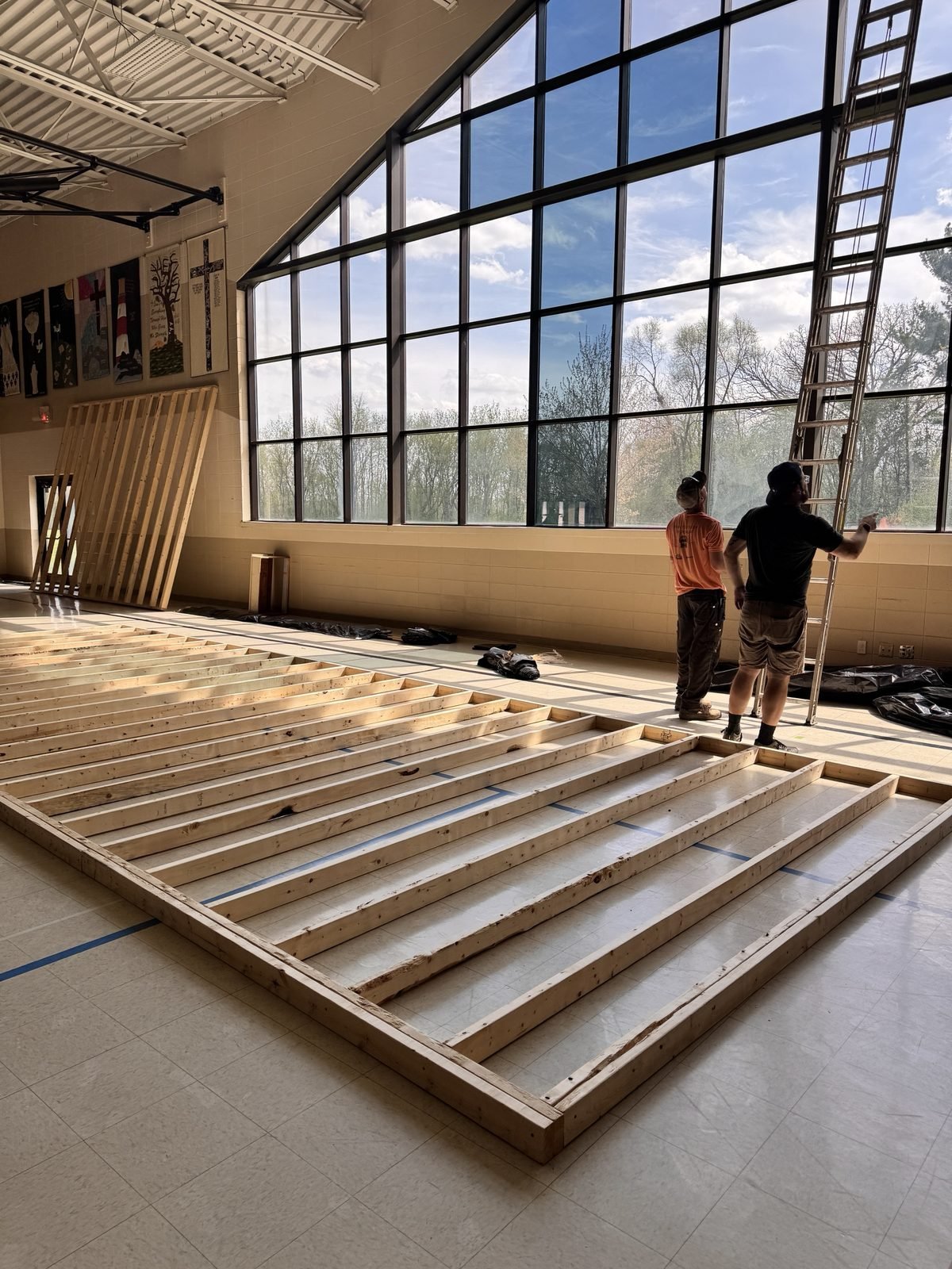 Stage wall framing laid out on the gym floor