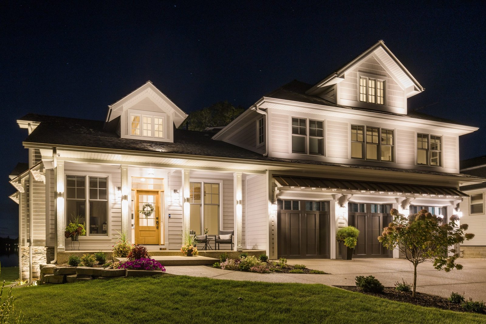 A Monien Construction lakehouse at dusk in Burlington, Wisconsin, its windows lit above the water