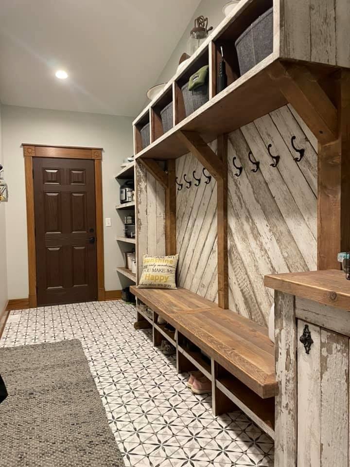 Custom mudroom with reclaimed wood lockers, bench, and patterned tile floor