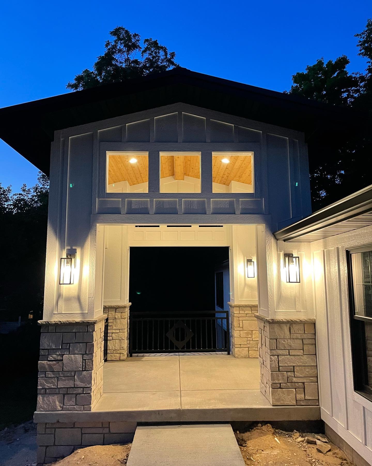 Stone and board and batten carriage house in evening light