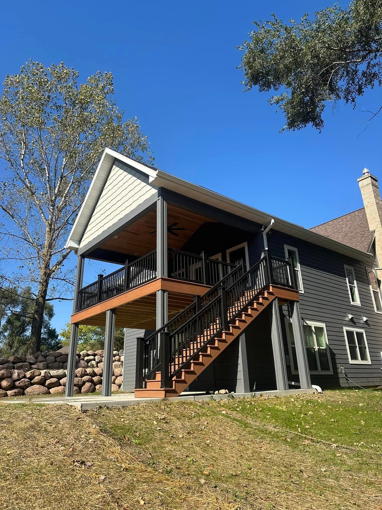 Elevated custom lake house with covered cedar deck built on a slope